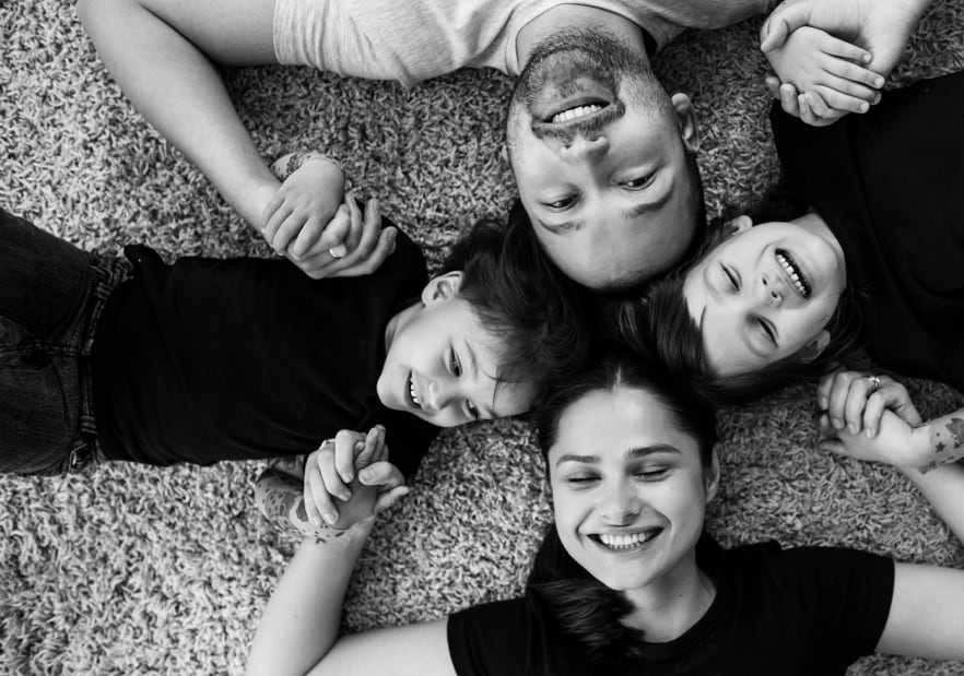 black and white photo of a family laying down smiling