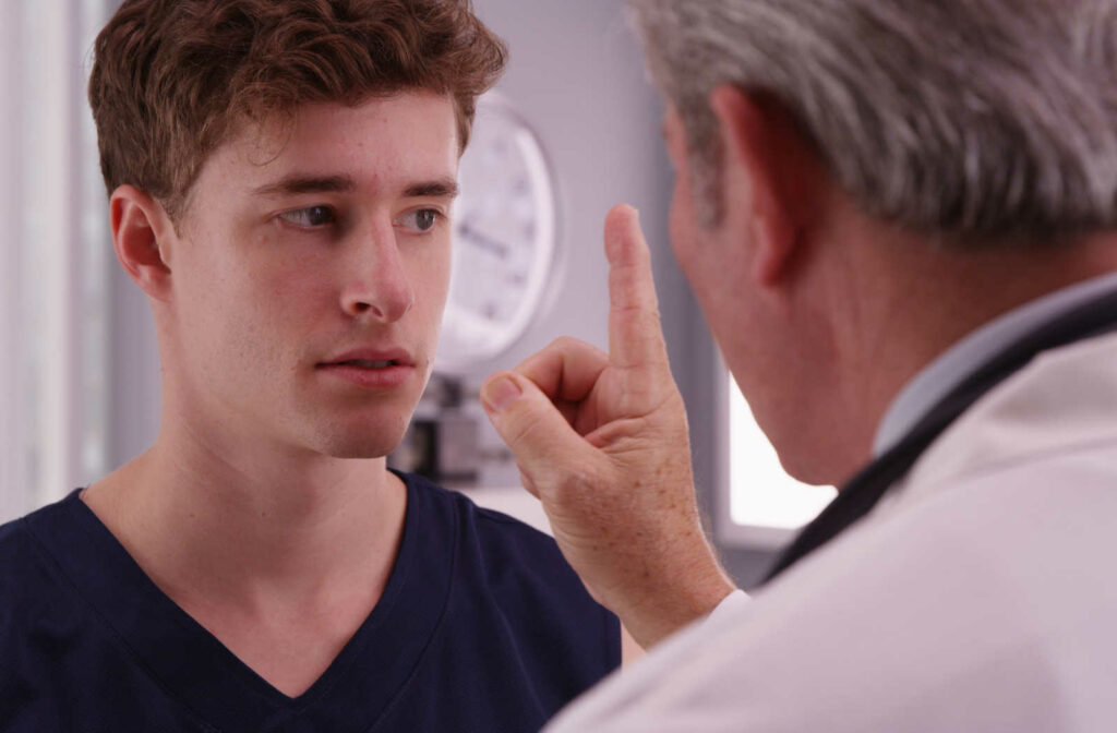 Young male patient has his vision examined by a doctor.