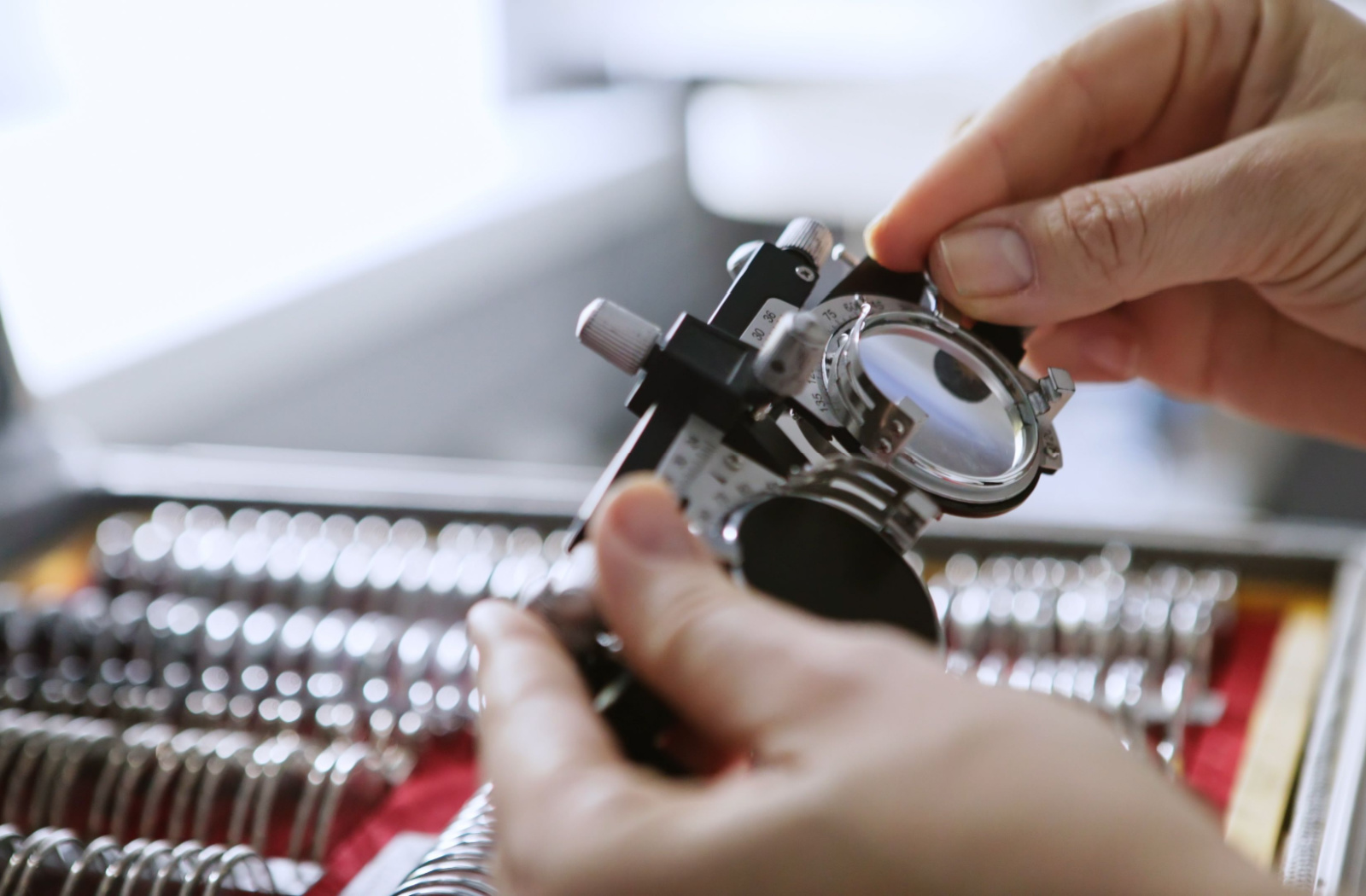 Optician loading a trial frame with lenses.