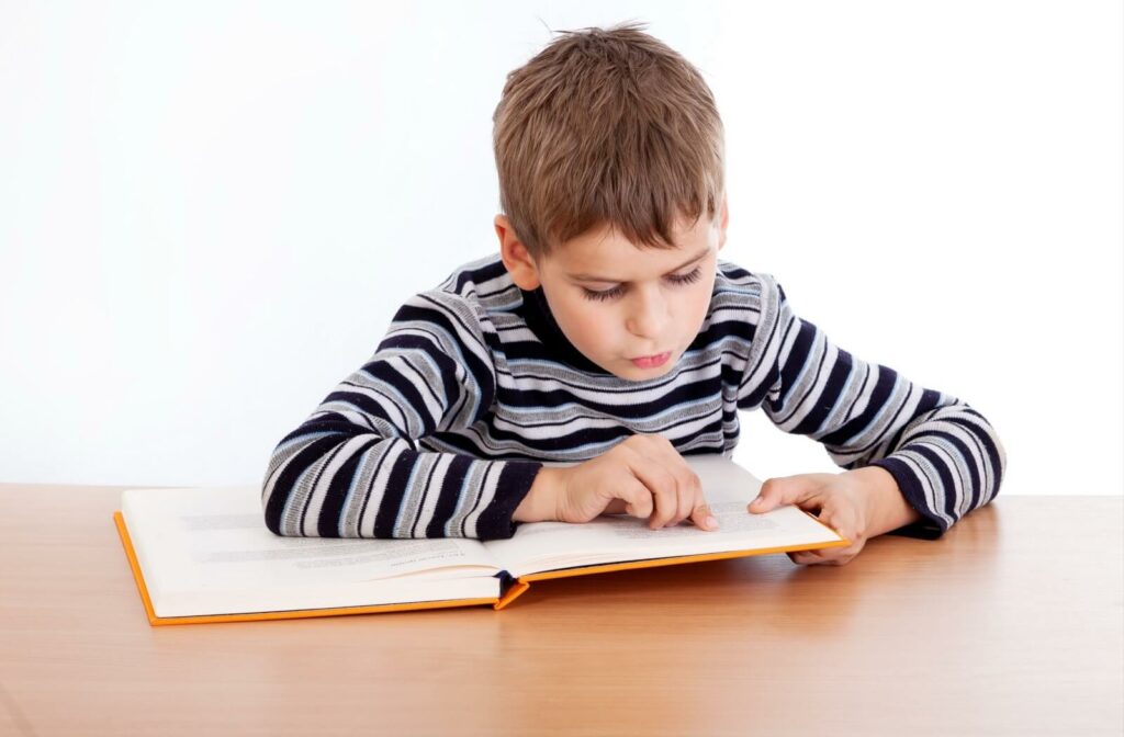 a child uses their finger to aid their reading because of eye tracking issues